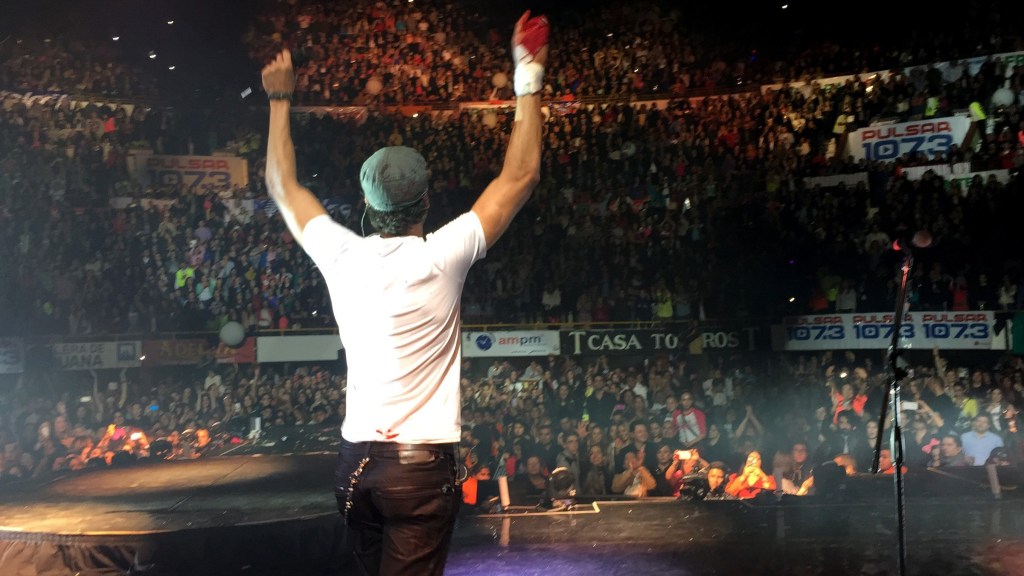Spanish pop star Enrique Iglesias holds up his bloodied hand cut by a drone.
