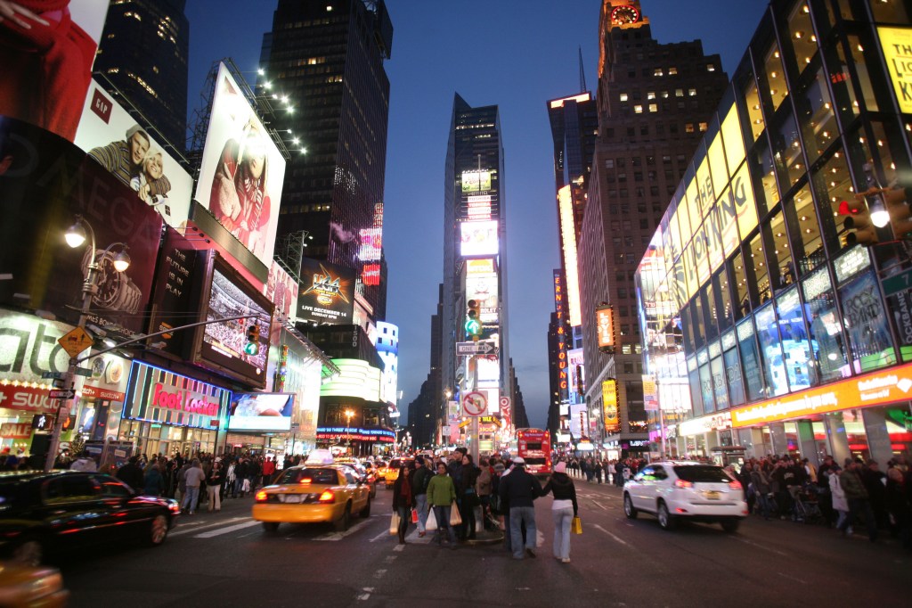 Shoppers crowd the streets of New York at night. Martin Keene/PA Wire
