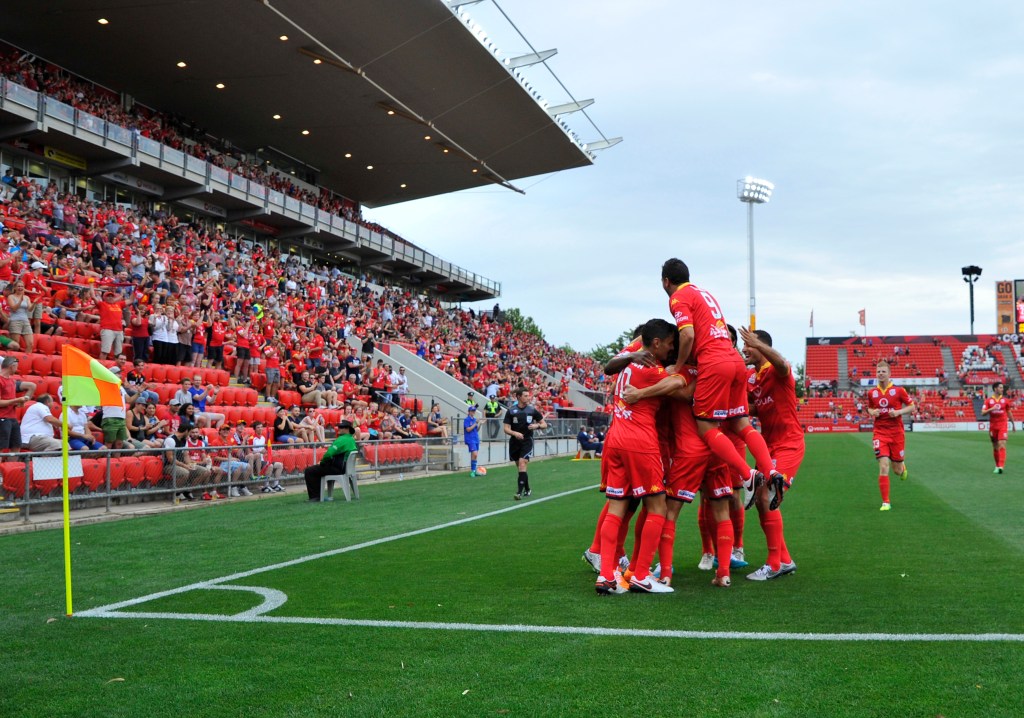 Adelaide United players celebrate an early goal against Perth Glory at Coopers Stadium on Sunday. AAP Image/David Mariuz