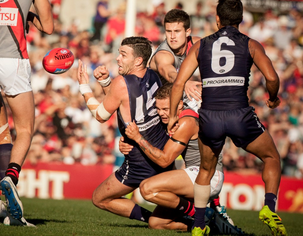 Ryan Crowley takes on the Bombers in 2014. He now says he wants to "protect" their younger players. Photo: Tony McDonough, AAP.