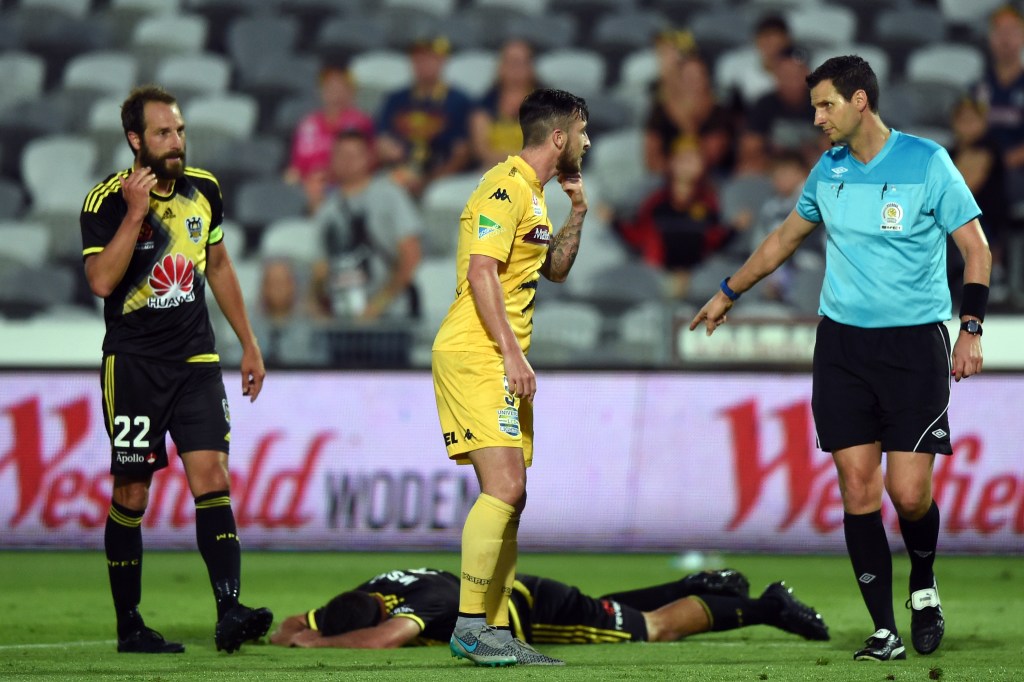 Referee Kris Griffiths-Jones talks to Mariners' Roy O'Donovan as Emmanuel Muscat of the Phoenix lays on the ground Photo: Paul Miller, AAP.