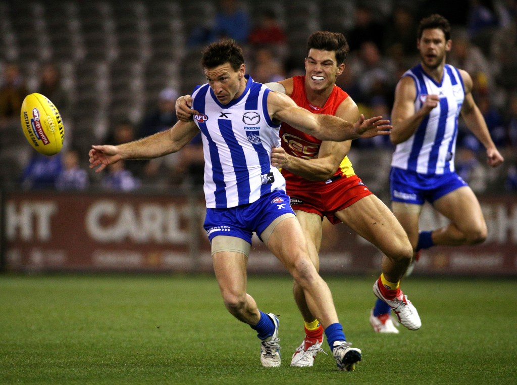 JAEGER BOMBSHELL? O'Meara tackles Kangaroo Brent Harvey in 2014 - but could he be suiting up in North Melbourne colours next year? Photo: Mark Dadwell, AAP.