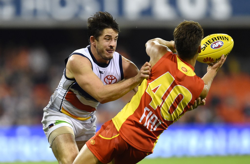Matthew Jaensch tackles Sean Lemons of the Gold Coast Suns. Photo: Dan Peled, AAP.