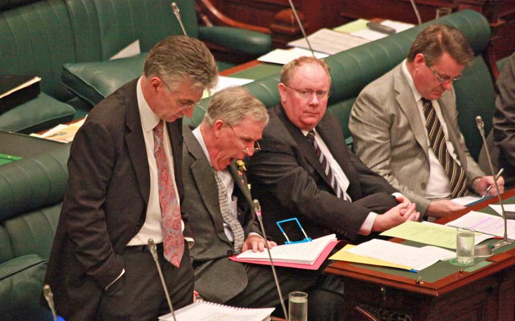 "I nicknamed him the anaesthetist." Michael Atkinson (second from left), yawns while John Hill (left) addresses Parliament.