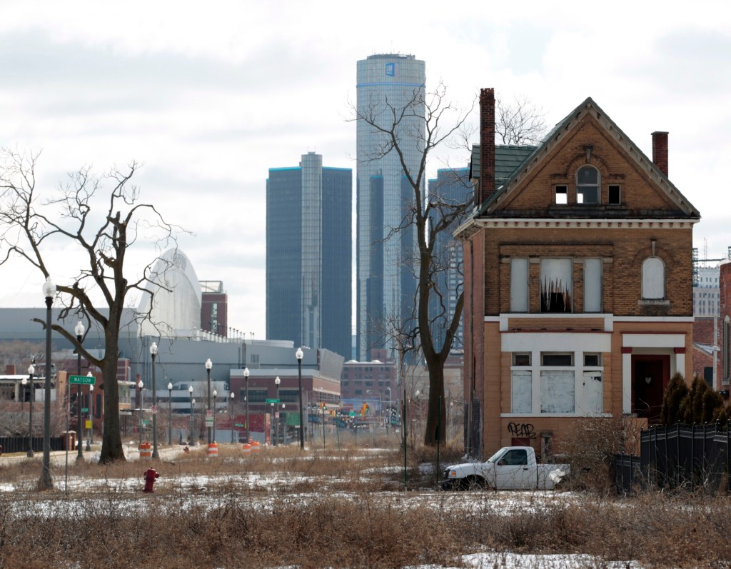 Scenes from the rust belt: a 2013 picture of an empty house with the GM building  in the background in downtown Detroit. Photo: EPA/Jeff Kowalsky