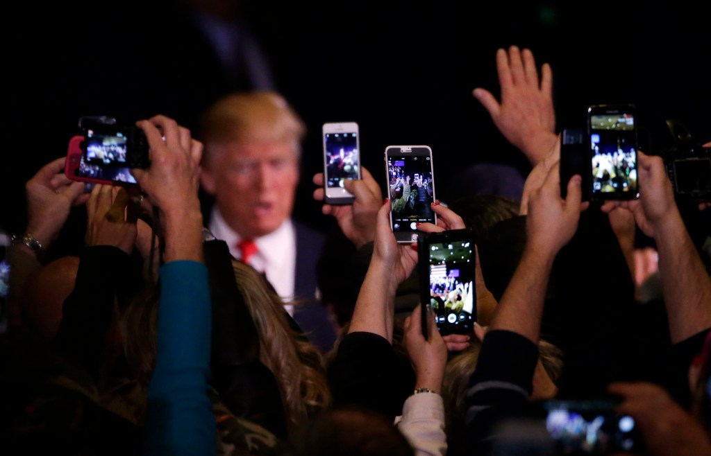 Supporters take photos of Donald Trump on their mobile phones. Photo: AP/Marcio Jose Sanchez