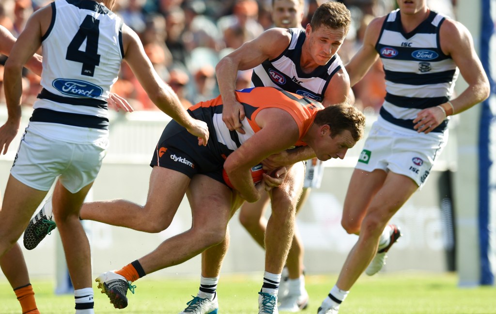 Cats captain Joel Selwood tackles former premiership teammate and now-Giant Steve Johnson. Photo: Lukas Coch, AAP.