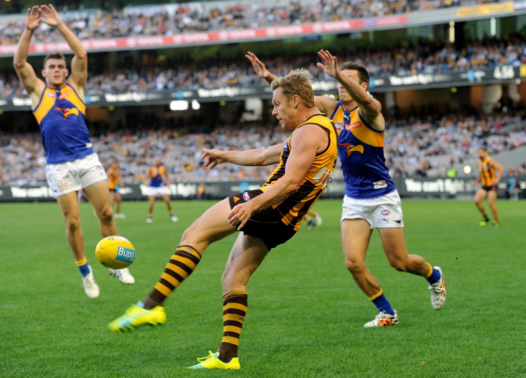 Sam Mitchell gets a kick away against the Eagles. Photo: AAP