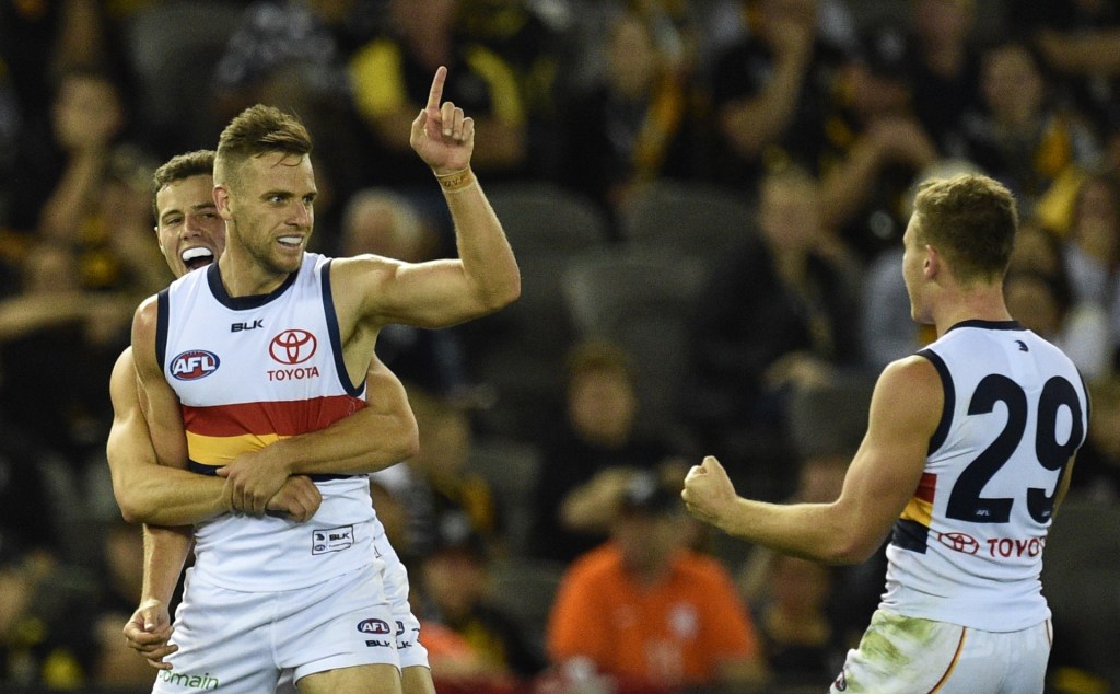 Luke Brown and Rory Laird get around 100-gamer Brodie Smith after one of his two goals on Saturday. Photo: Julian Smith, AAP.