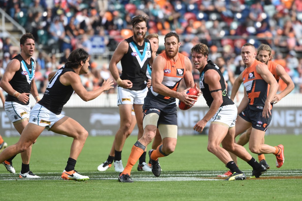 Shane Mumford clears the ball under pressure. Photo: Mick Tsikas, AAP.