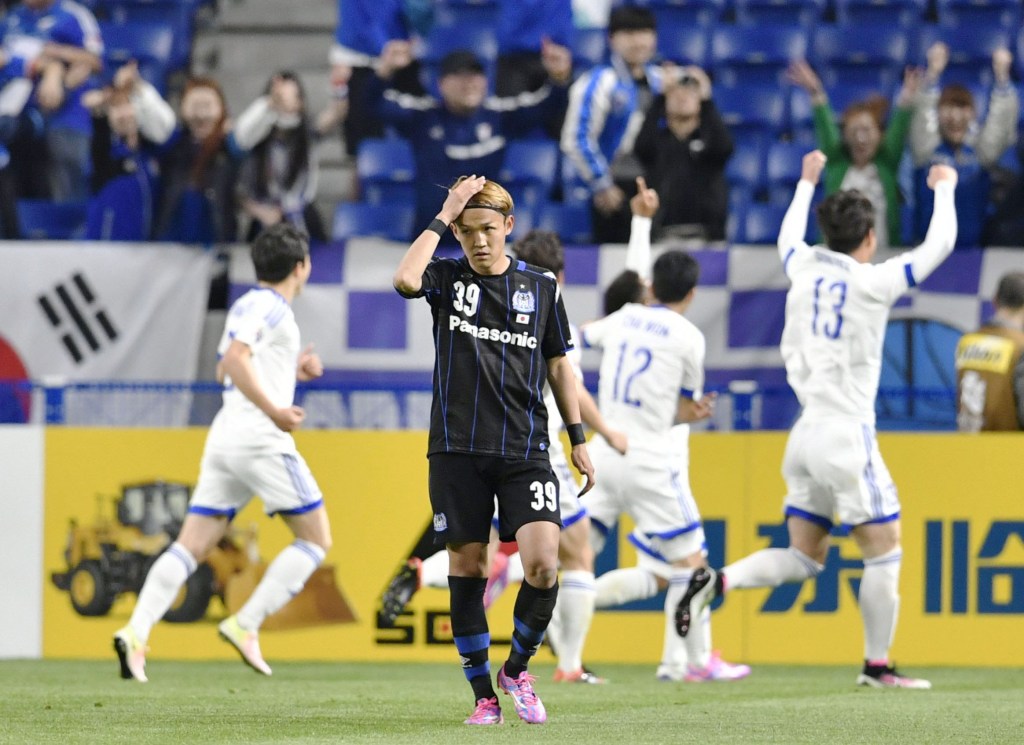 South Korea's Suwon Samsung Bluewings FC players celebrate after their side's second goal while Gamba Osaka striker Takashi Uami looks forlorn. The loss sent Gamba crashing out of the ACL in the first round - a boon for Sydney FC.