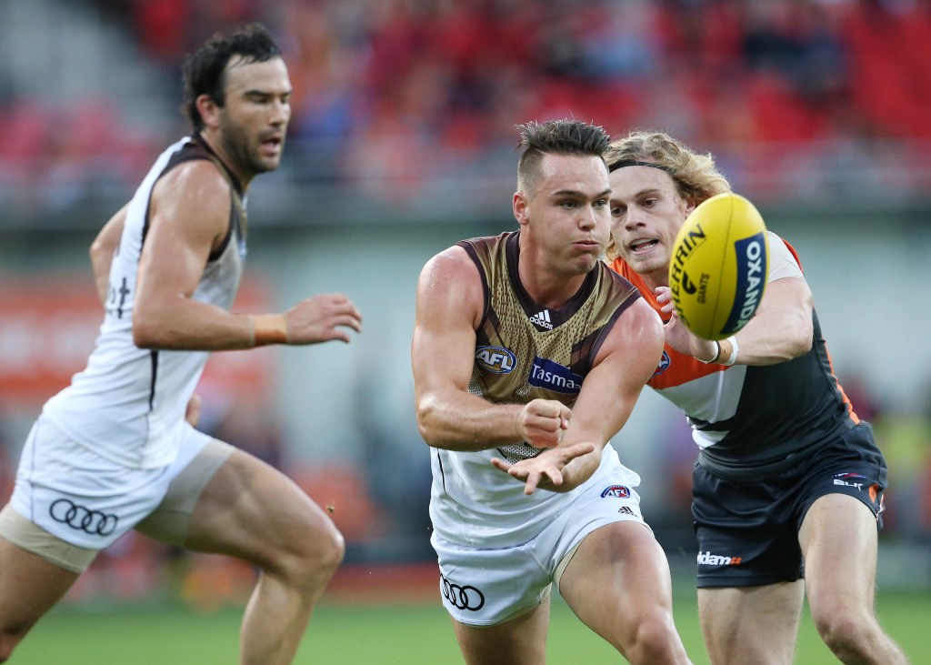 Jordan Lewis watches teammate Kieran Lovell dish off the ball during the Hawks' smashing by GWS. Photo: David Moir, AAP.