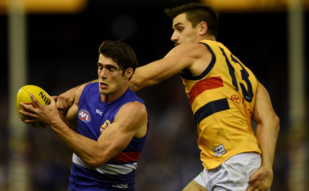 FREE KICK BULLDOGS! An unlucky Tex Walker lays a hand on Easton Wood. Photo: Tracey Nearmy, AAP.