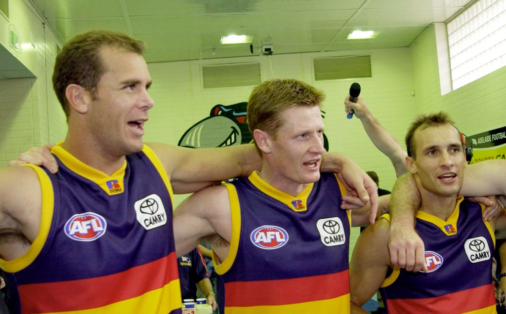 PRO HART: New AFL Hall of Fame inductee Ben Hart celebrates a 2003 win with former teammates Wayne Carey and Tyson Edwards. Photo: Tom Miletic, AAP.