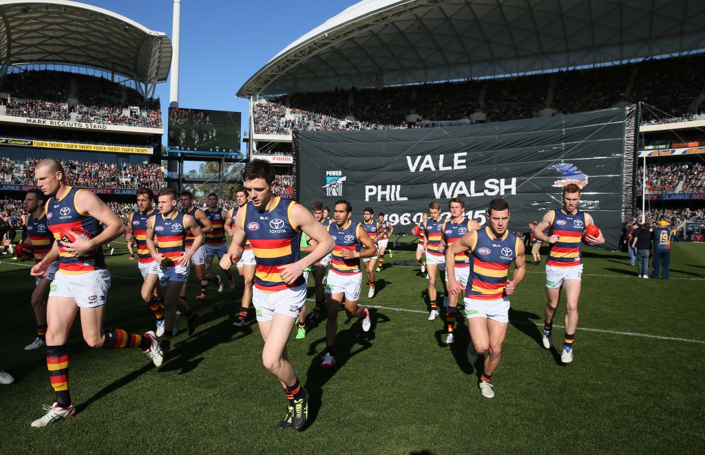 Crows and Port Adelaide players ran through the same banner as a tribute to Phil Walsh before last year's Showdown. Photo: Ben Macmahon, AAP.