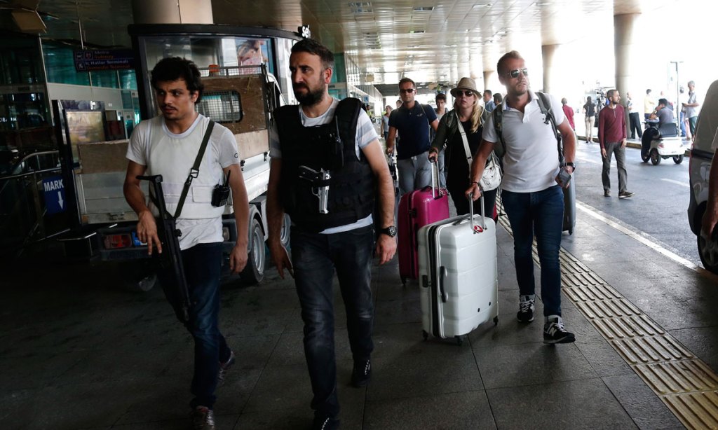 Armed Turkish policemen patrol as tourists arrive at the reopened airport in Istanbul. Photo: AAP