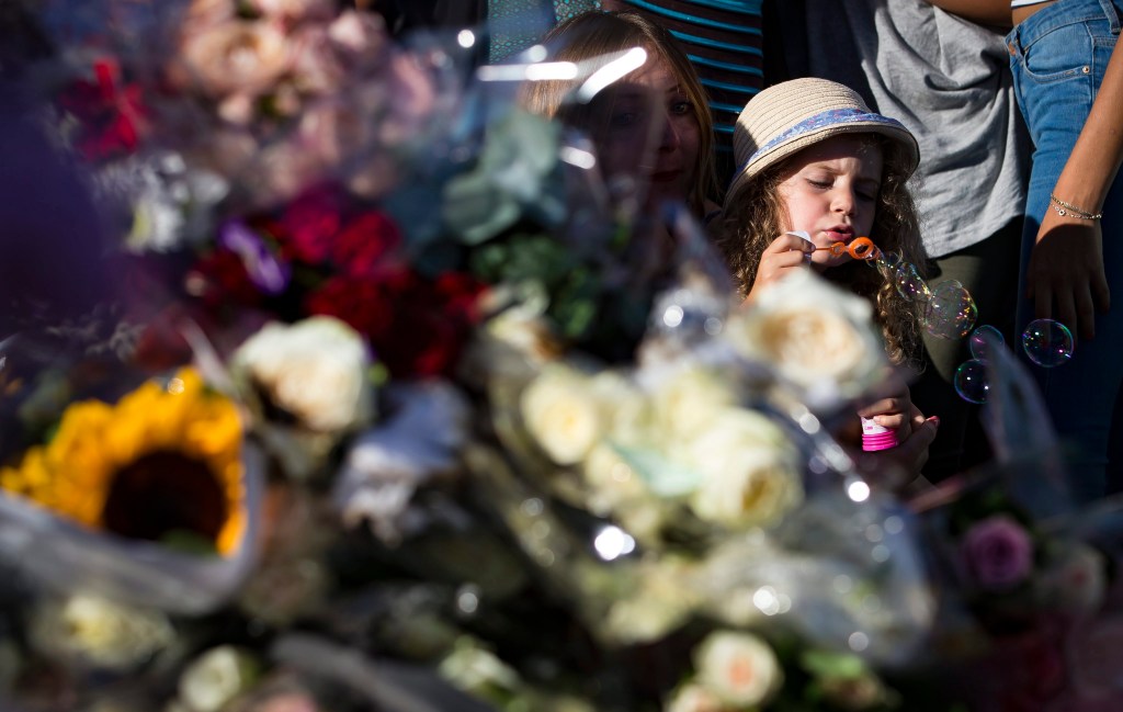 A child blows bubbles as people gather in front of a memorial on the 'Promenade des Anglais' where the Bastille Day atrocity occurred. Photo: EPA
