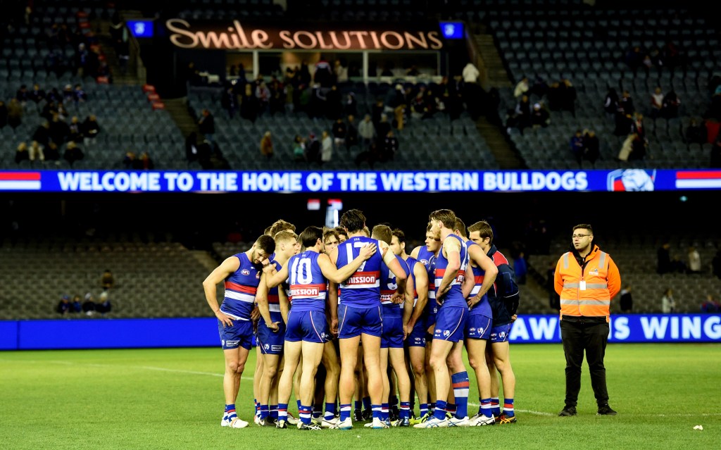 Bulldogs players console each other before walking off the field after Saturday's devastating defeat. Photo: Tracey Nearmy, AAP.