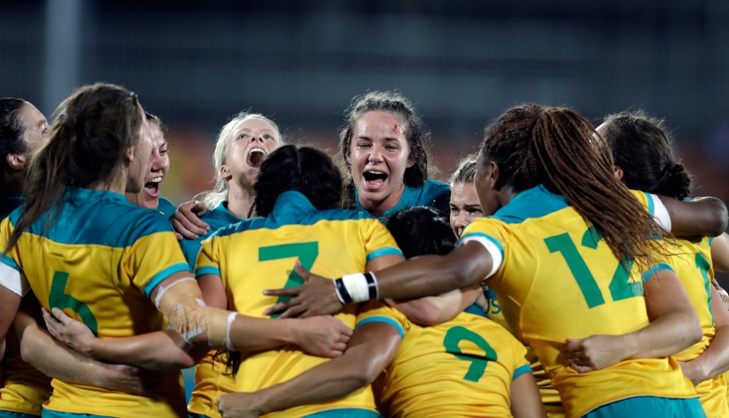 Australia's players celebrate after winning the women's rugby sevens gold medal match against New Zealand. Photo: Themba Hadebe, AP.