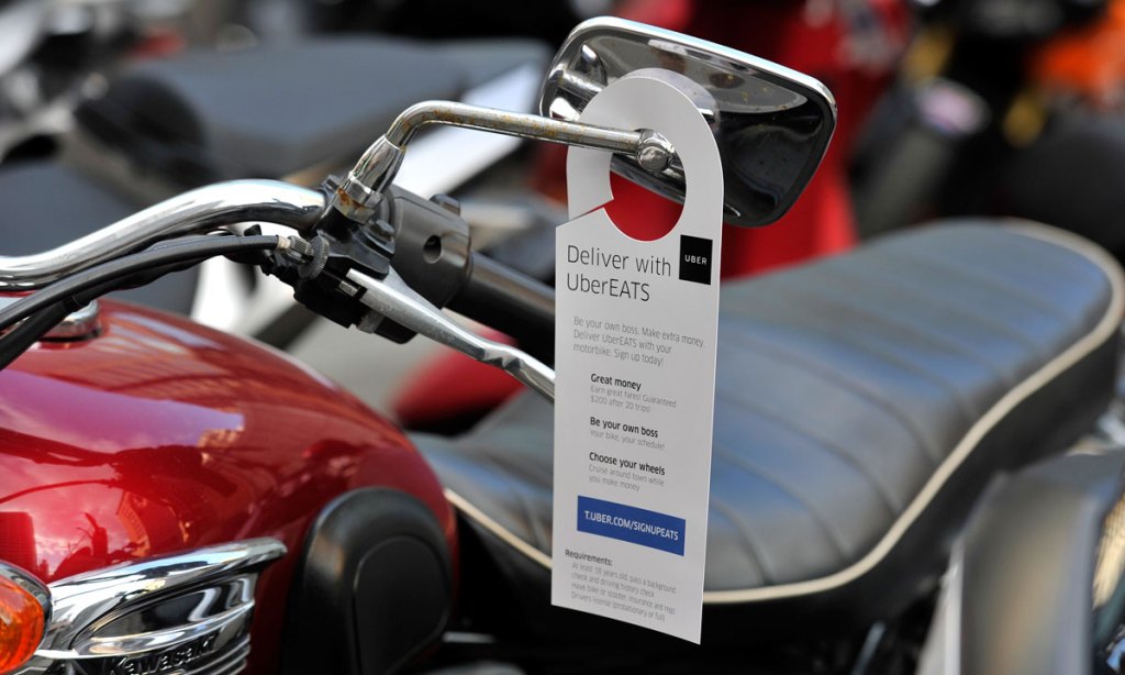 A note on a motorbike seeking drivers for UberEATS in Sydney. Photo: AAP