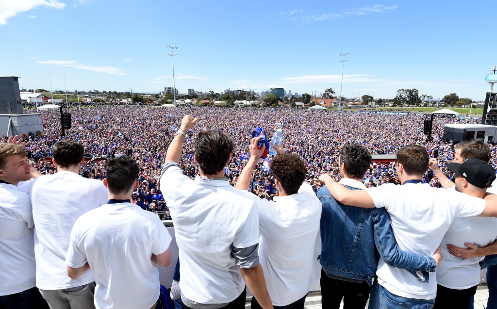 Western bulldogs players salute their fans at Whitten Oval after their historic Grand Final win. Photo: Tracey Nearmy / AAP