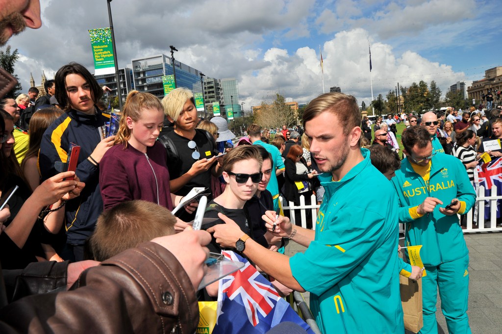 Kyle Chalmers joins other Australian Olympians signing autographs on Victoria Square in a September homecoming parade. Photo: David Mariuz / AAP
