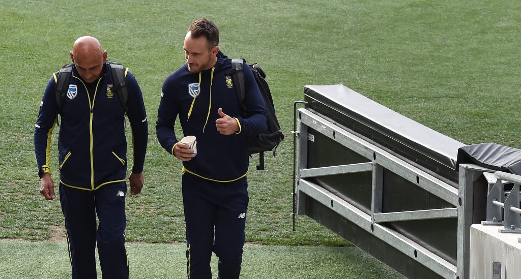 South African captain Faf du Plessis gives the thumbs up as he leaves his ICC hearing at Adelaide Oval yesterday, flanked by the Proteas' head of security Zunaid Wadee, who earlier this week was involved in a scuffle with a journalist. Photo: Dave Hunt / AAP