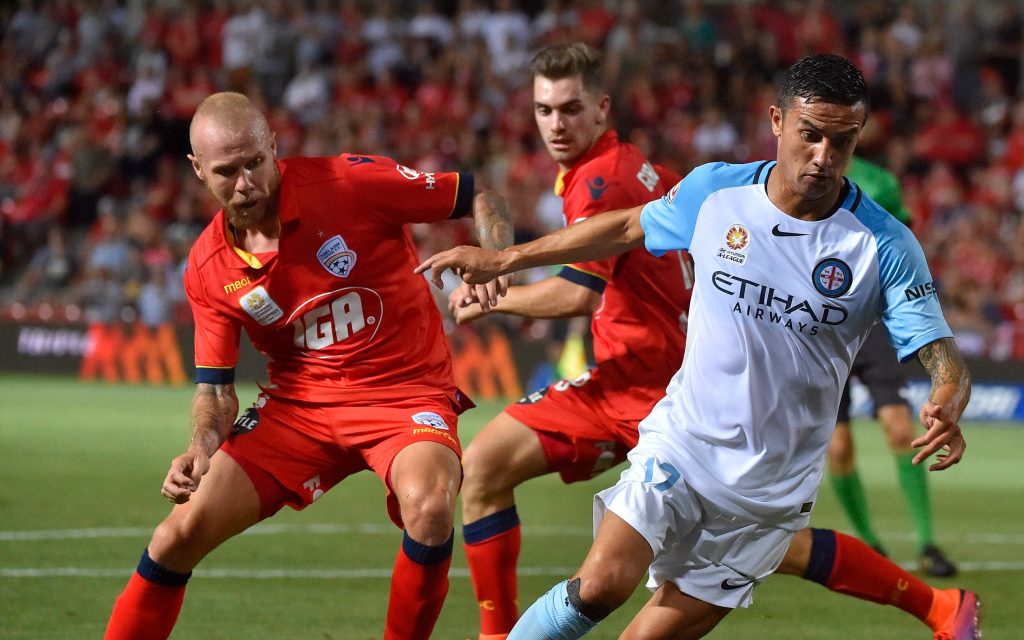 Adelaide's Taylor Regan tracking Melbourne City millionaire Tim Cahill. Photo: AAP/David Mariuz