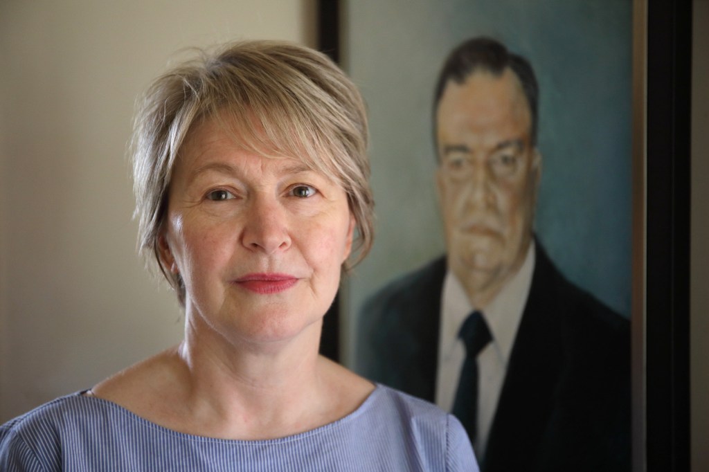 Lyn Such in front of a portrait of her late husband Bob. Photo: Tony Lewis / InDaily