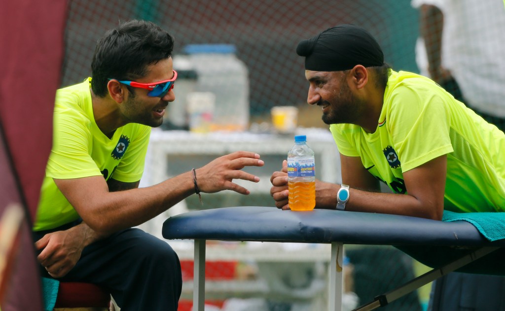 Virat Kohli sharing a light moment with then-teammate Harbhajan Singh in 2012. Photo: Eranga Jayawardena / AP