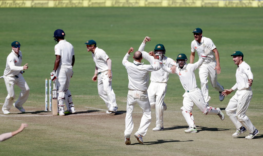 The Australian team, with captain Steve Smith left, celebrate the final Indian wicket in Pune. Photo: Rajanish Kakade / AP
