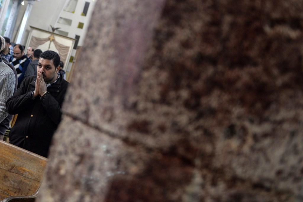 A man behind a blood-stained column at the scene of a bomb explosion inside Mar Girgis church in Tanta, 90km north of Cairo. Photo: EPA/Mohamed Hossam