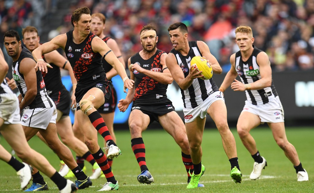Scott Pendlebury gets one of his 20 touches against Essedon in yesterday's Anzac Day clash. Photo: AAP/Julian Smith