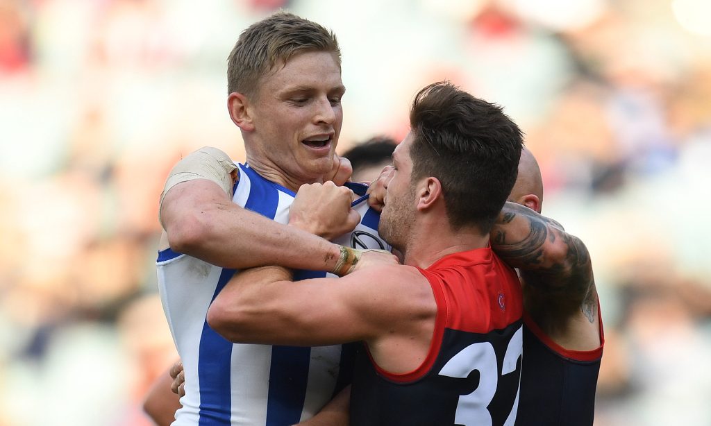 Tomas Bugg of the Demons gets hold of North Melbourne's Jack Ziebell during Sunday's spiteful encounter. Photo: Julian Smith / AAP