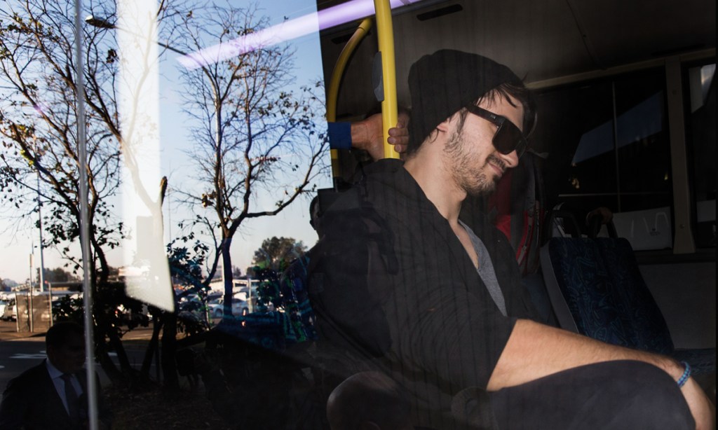 Cassandra Sainsbury's fiancé Scott Broadbridge is escorted to a bus at Sydney Airport. Photo: AAP