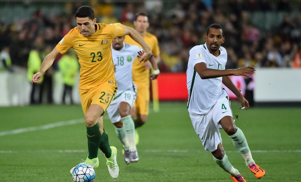 Tom Rogic with Saudi Arabia's Abdulla Aldossary in pursuit. Photo: David Mariuz / AAP