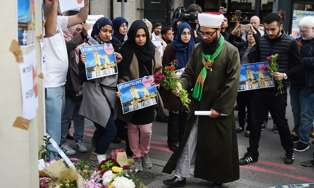 United we stand: members of London's Muslim community place flowers near the site of the attack at Borough Market. Photo: EPA
