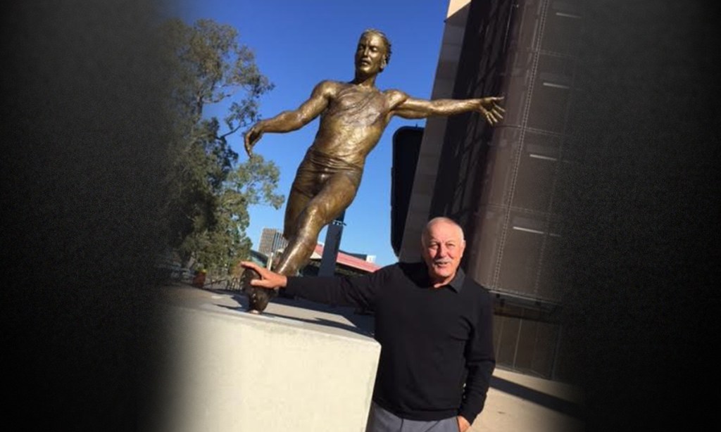 AFL Legend Malcolm Blight poses with his statue today. Photo: Steve Larkin / AAP