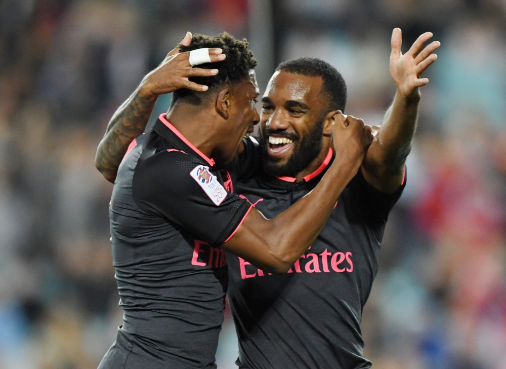 Alexandre Lacazette celebrates with Arsenal teammate Alex Iwobi after getting a goal past Redmayne last night. Photo: David Moir / AAP