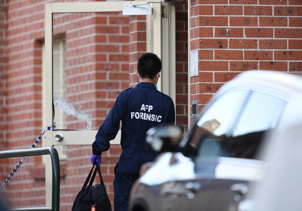 An Australian Federal Police forensic officer enters the main door of a building in Lakemba in Sydney this week. Photo: AAP/David Moir