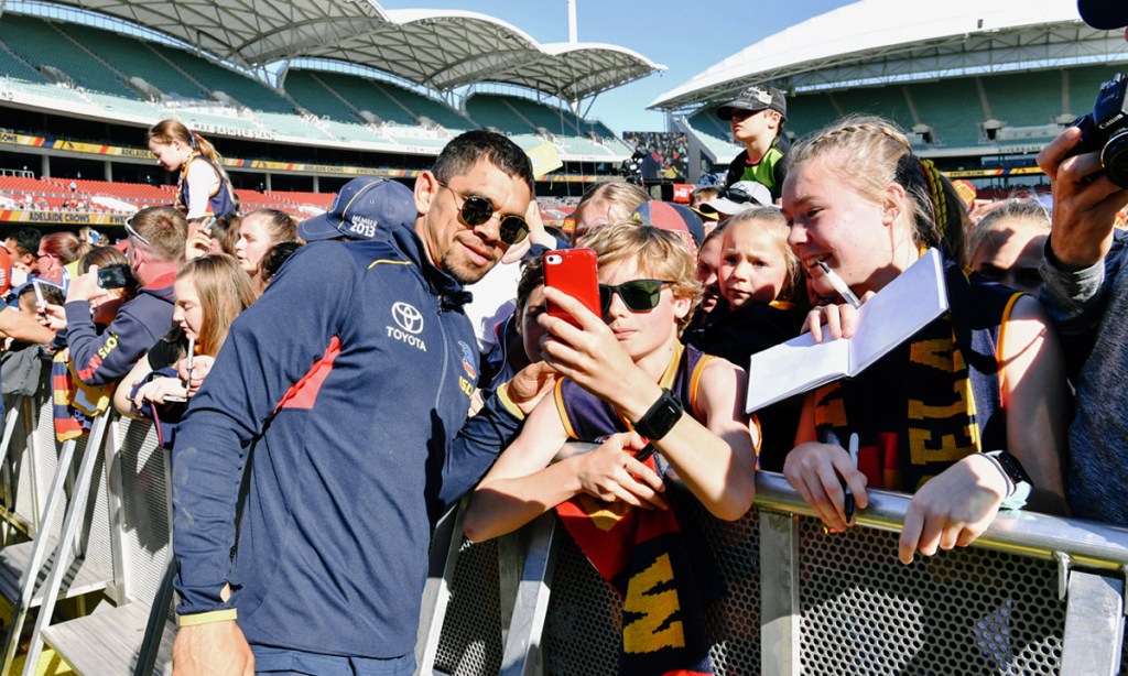 Charlie Cameron of the Adelaide Crows is seen taking a selfie with the crowd after arriving at Adelaide Oval earlier this month to a welcoming home from fans after the AFL Grand Final. Photo: AAP/Morgan Sette