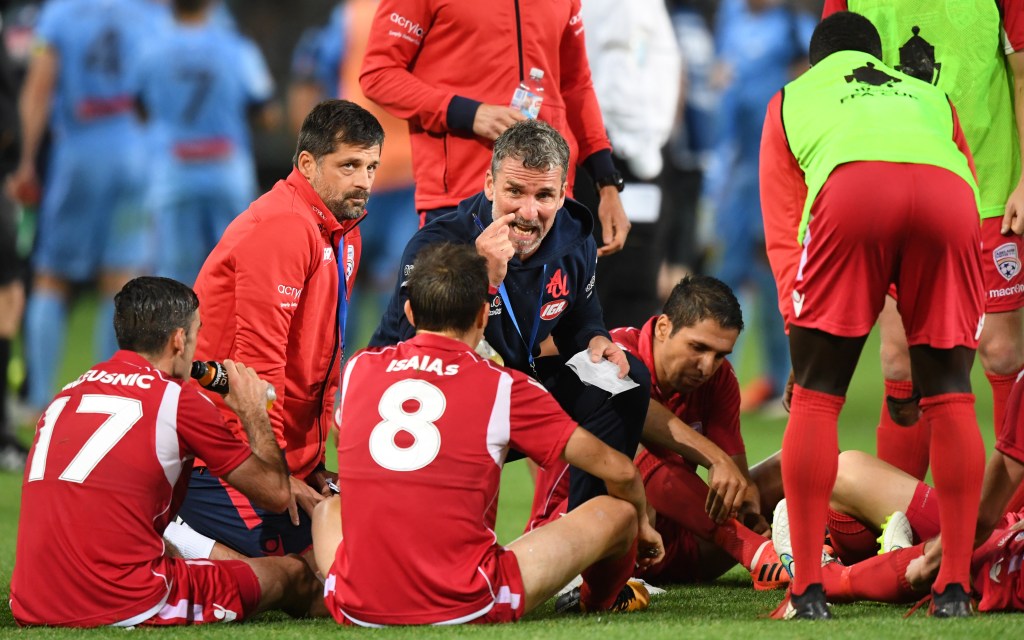 Marco Kurz speaks to Adelaide players before extra time last night. Photo: David Moir / AAP