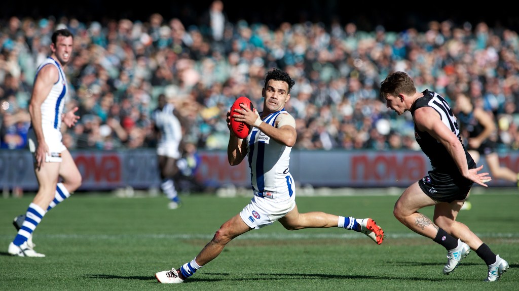 Lindsay Thomas evades the chase of Port Adelaide's Matt White. Photo: Michael Errey/InDaily