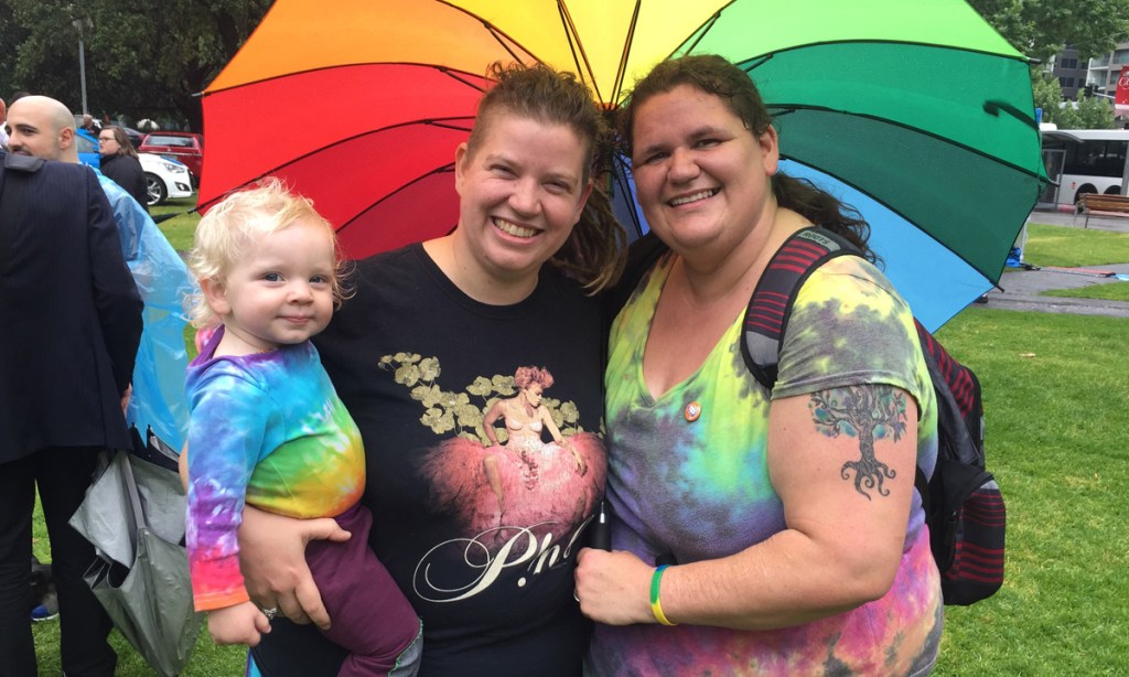 Rose*, her partner Sarah and their daughter Poppy at this morning's marriage equality official results event in Hindmarsh Square. Photo: Bension Siebert / InDaily