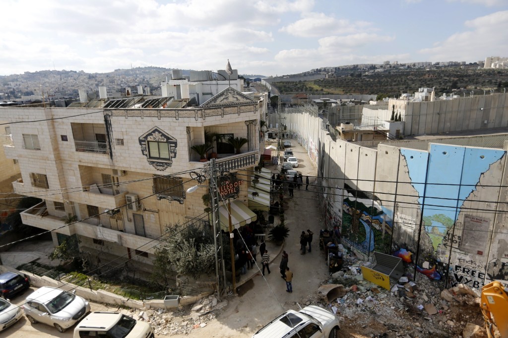 Tourists stand in front of the Walled Off Hotel by British street artist Banksy in Bethlehem, only metres from Israel's separation wall. Photo: EPA/Abed Al Hashlamoun