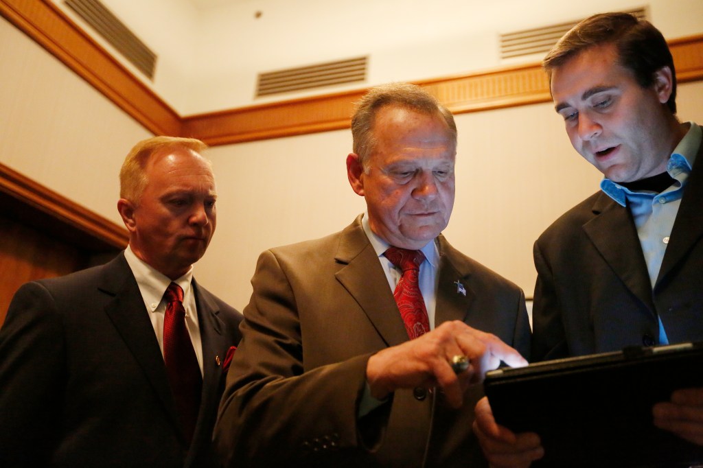 US Senate candidate Roy Moore (centre) looks at election returns with staff during an election-night watch party. Photo: AP/Brynn Anderson