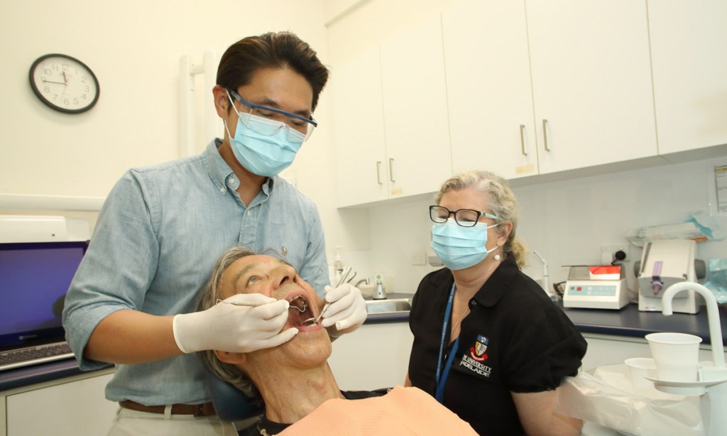 Dentistry student Adrian Wun and dental assistant Amanda Drewer with patient Ted Thornbury, who says the service has improved his confidence. Photo: Tony Lewis / InDaily