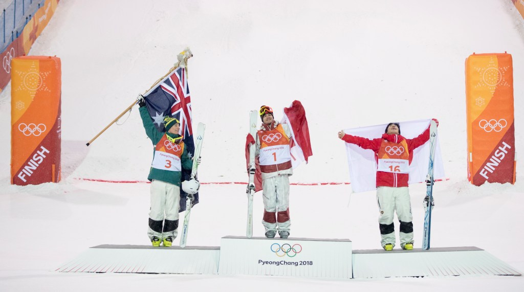 Gold medal winner Canadian Mikael Kingsbury, centre, shares the podium with silver medal winner Australia's Matt Graham, left, and bronze medal winner Daichi Hara, of Japan, following moguls finals at the Phoenix Snow Park at the Pyeongchang 2018 Winter Olympic Games in South Korea, Monday, Feb. 12, 2018. (Jonathan Hayward/The Canadian Press via AP)