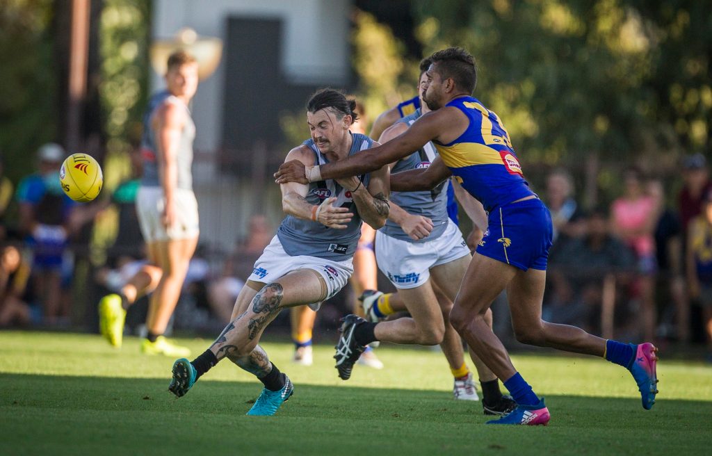 Jasper Pittard of Port Adelaide gets a kick away under pressure from Lewis Jetta. Photo: AAP/Tony McDonough