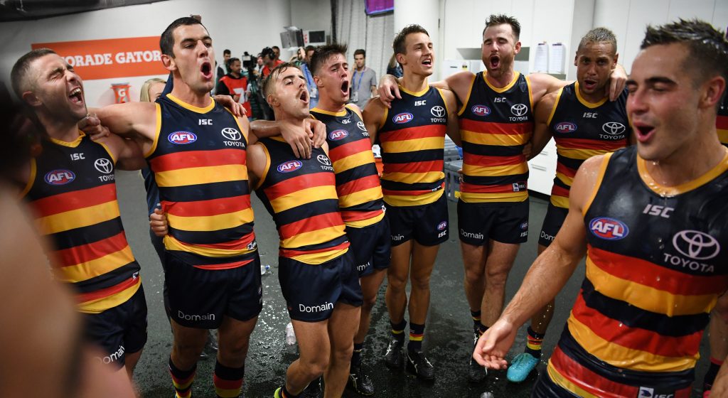 Four-goal skipper Tex Walker (second from left) leads his team in the club song after a memorable debut for Myles Poholke (right). Photo: David Moir / AAP